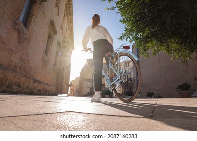 Young Woman Seen From Behind Takes A Bike Ride In An City Break