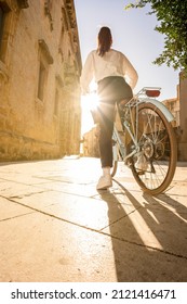 Young Woman Seen From Behind Takes A Bike Ride In An City Break