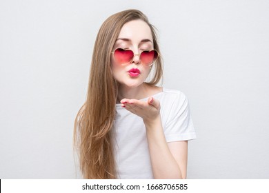 Young Woman Sends Air Kiss, Girl Heart-shaped Glasses, White Background, Copy Space