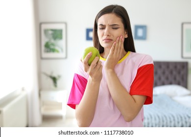 Young Woman With Sensitive Teeth And Apple At Home