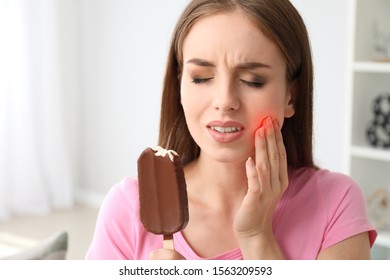 Young Woman With Sensitive Teeth And Cold Ice-cream At Home