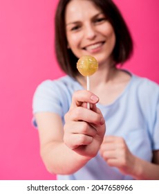 Young Woman With Sensitive Teeth Eating Sweet Lollipop On Color Background