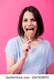 Young Woman With Sensitive Teeth Eating Sweet Lollipop On Color Background