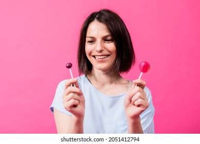 Young Woman With Sensitive Teeth Eating Sweet Lollipop On Color Background