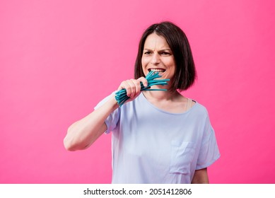 Young Woman With Sensitive Teeth Eating Sweet Candies On Color Background