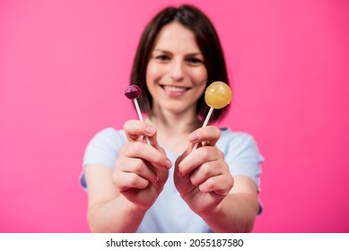 Young Woman With Sensitive Teeth Eating Sweet Lollipop On Color Background