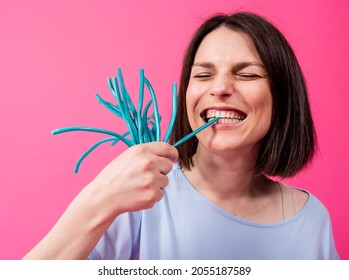 Young Woman With Sensitive Teeth Eating Sweet Candies On Color Background