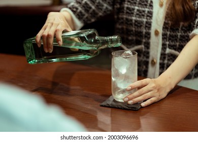 Young Woman Serving Liquor At The Counter Bar