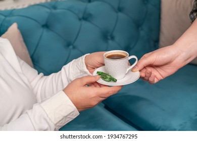 Young woman serving Turkish traditional coffee. Two women drink coffee together. Neighborhood and coffee brake. Mother and daughter or daughter-in-law and mother-in-law together concept.