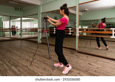 Young Woman Sets Up Camera To Record Dance Lesson In Choreography Hall With Mirrors