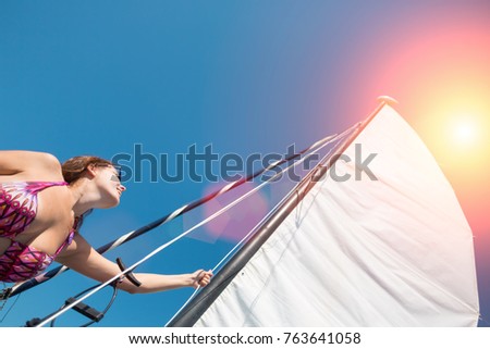 Young woman sets sail on yacht or boat, bottom view