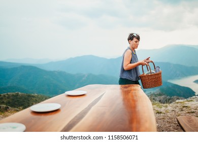 Young Woman Setting The Table For Dinner Outside