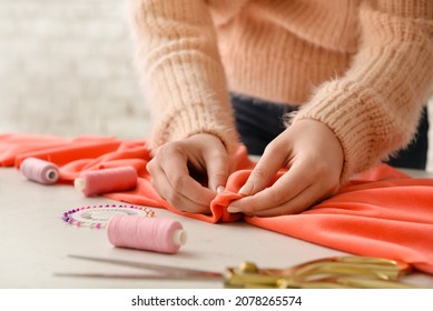 Young woman sewing clothes in studio