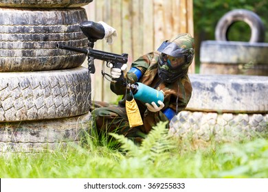 Young Woman Shooting From Paintball Gun