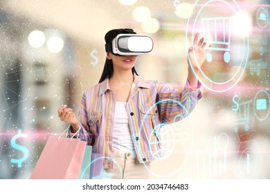 Young woman with shopping bags using virtual reality headset in simulated store - Shutterstock ID 2034746483