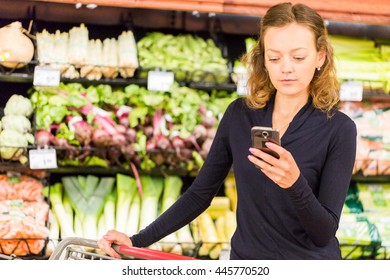 Young woman shopping in the fresh produce section at the grocery store.