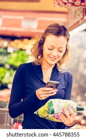 Young Woman Shopping In The Fresh Produce Section At The Grocery Store.