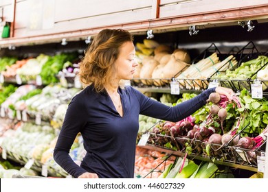 Young Woman Shopping In The Fresh Produce Section At The Grocery Store.