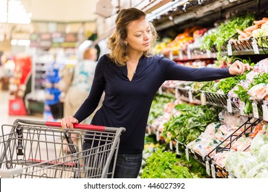 Young Woman Shopping In The Fresh Produce Section At The Grocery Store.