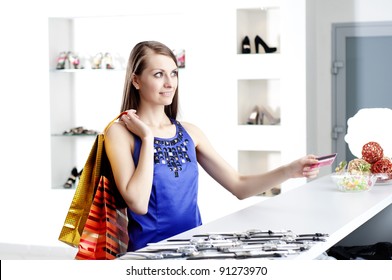 Young Woman At Shopping Mall Checkout Counter Paying Through Credit Card