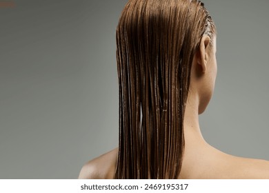 A young woman showcases her hair care routine with wet, flowing locks. - Powered by Shutterstock