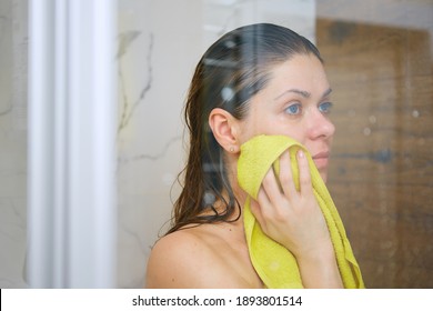 Young Woman In Shower Stall Drying Face Off With A Yellow Towel After Bathing.