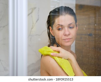 Young Woman In Shower Stall Drying Face Off With A Yellow Towel After Bathing.