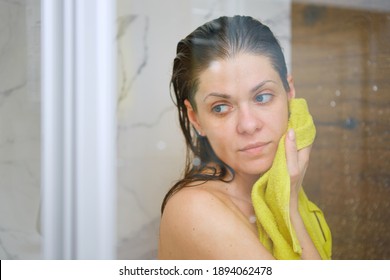 Young Woman In Shower Stall Drying Face Off With A Yellow Towel After Bathing.