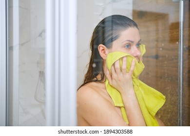 Young Woman In Shower Stall Drying Face Off With A Yellow Towel After Bathing.