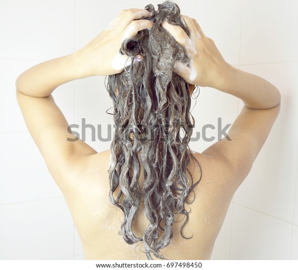シャワーで洗髪した若い女性 長い髪の毛を洗いながら見る美しい女性 シャワーにブルネットの多人種の女性モデル の写真素材 今すぐ編集