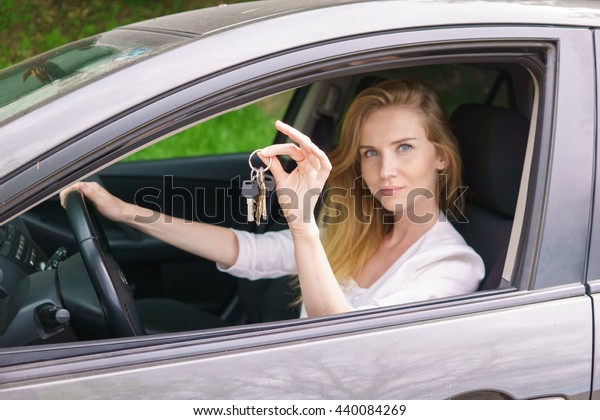 Young woman showing car\
key