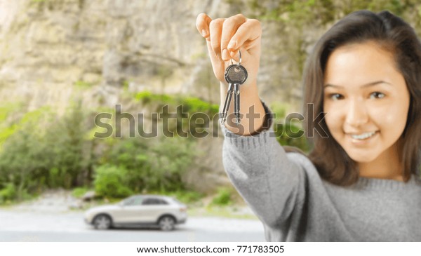 Young woman showing car
key