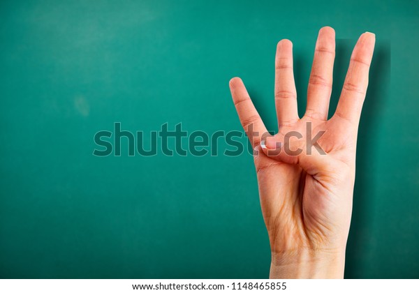 Young woman showing\
four fingers with hand