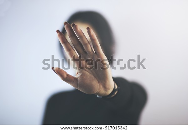 Young woman\
showing her denial with NO on her\
hand