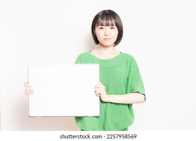 Young woman showing a large sketchbook. - Shutterstock ID 2257958569