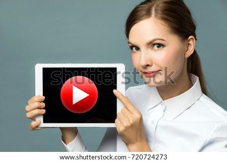 Young woman showing movie play button.