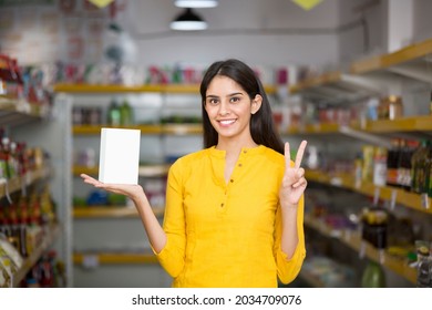 Young Woman Showing Product At Super Market