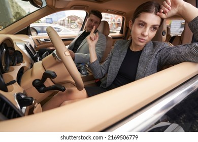 Young Woman Showing Rude Gesture To Man In Car