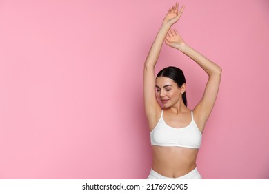 Young woman showing smooth skin after epilation on pink background, space for text