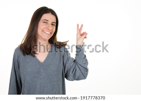 Young woman showing v two fingers, positive and peace gesture hand on white background