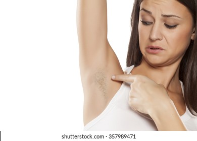 young woman shows her unshaved armpit 