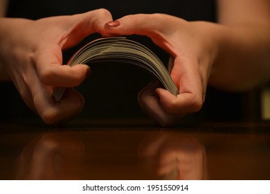 Young Woman Shuffling Deck Of Cards