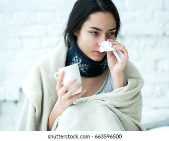 Young woman sick in bed with temperature drinks hot. Indoor shot. - Shutterstock ID 663596500