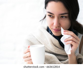 Young woman sick in bed with temperature drinks hot. Indoor shot. - Shutterstock ID 663612814