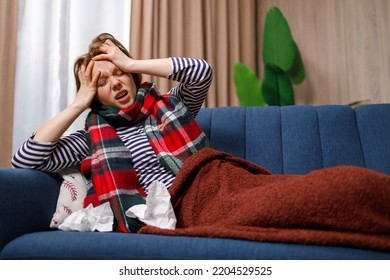 Young Woman Sick With Flu Virus Suffering From Severe Headache While Lying On Couch