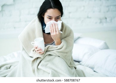Young woman sick with temperature drinks hot  - Shutterstock ID 588708767
