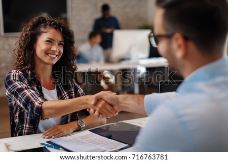 Young woman signing contracts and handshake with a manager