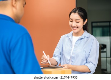 Young woman signing electronic Signature on tablet for agreement of contract digital receiving parcel from blue delivery man from shopping online. Courier man delivering package to destination. - Shutterstock ID 2174447933