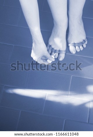 Young woman with silicone toe separator to separate toes to pedicure and paint or file toenails.