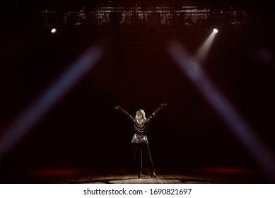 A Young Woman Singer On Stage During A Concert View From The Back